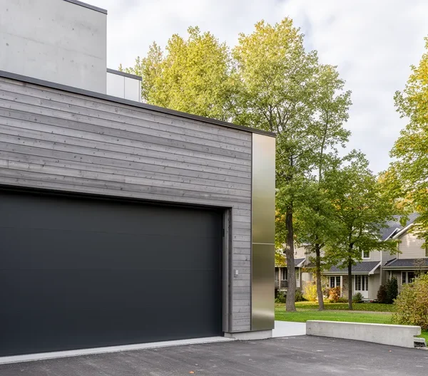 Façade de maison contemporaine québécoise avec porte de garage anthracite intégrée harmonieusement